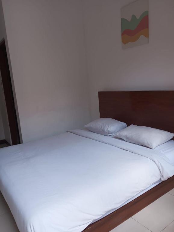2 Betten in einem Schlafzimmer mit weißer Bettwäsche und Kissen in der Unterkunft Amelle Villas & Residences Canggu in Canggu