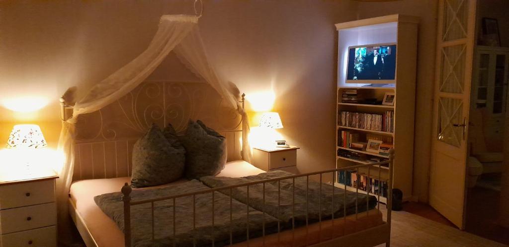a bedroom with a canopy bed and a tv at Ferienwohnung Madlein in Rehna