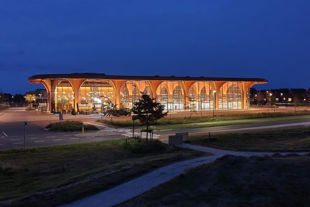 フローニンゲンにあるLong-stay family house Meerstadの夜間の窓が多い大きな建物