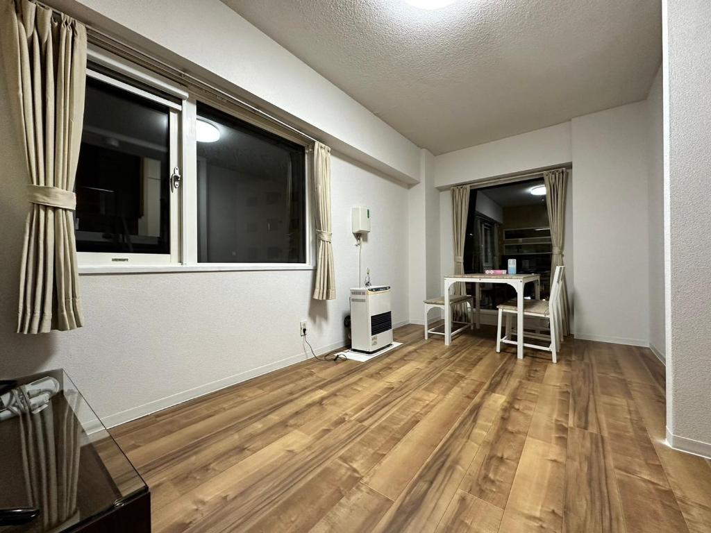 an empty living room with a table and a window at 【NEW OPEN】AMS Hiragishi 402 in Sapporo