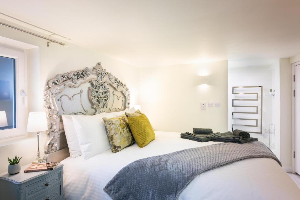 a bedroom with a large white bed with yellow pillows at Gorgeous Boutique Flat Sleeps 2 in Lyme Regis in Lyme Regis