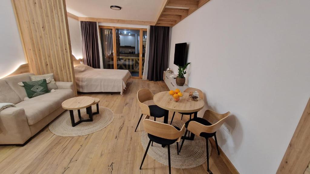 ein Wohnzimmer mit einem Tisch, Stühlen und einem Sofa in der Unterkunft Vuk Vučko in Jahorina