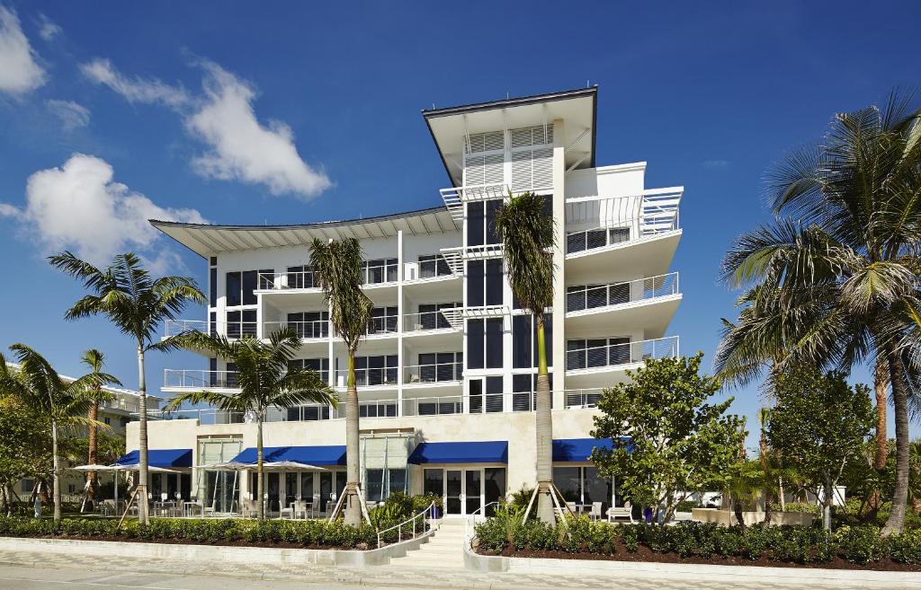 een wit gebouw met palmbomen ervoor bij Royal Blues Hotel in Deerfield Beach