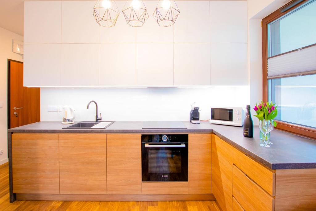 a kitchen with white cabinets and a sink at High Standard studio. City Center. Free parking. in Warsaw