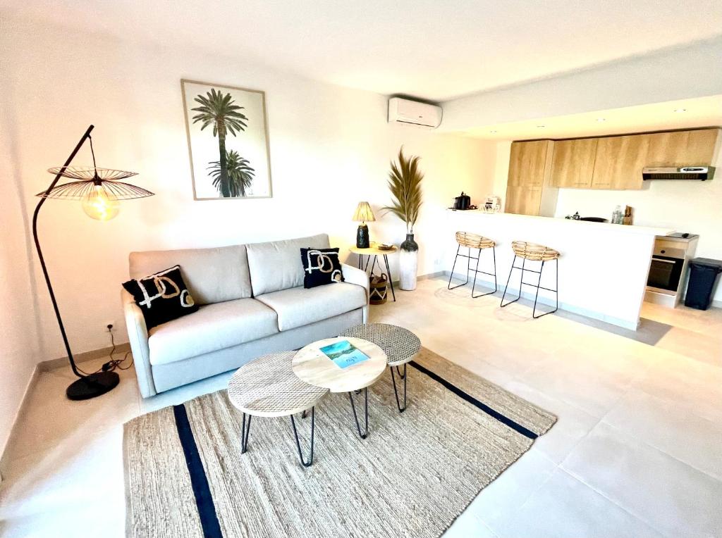 uma sala de estar com um sofá e uma mesa em Cottage Sable et Soleil em Anse Marcel 