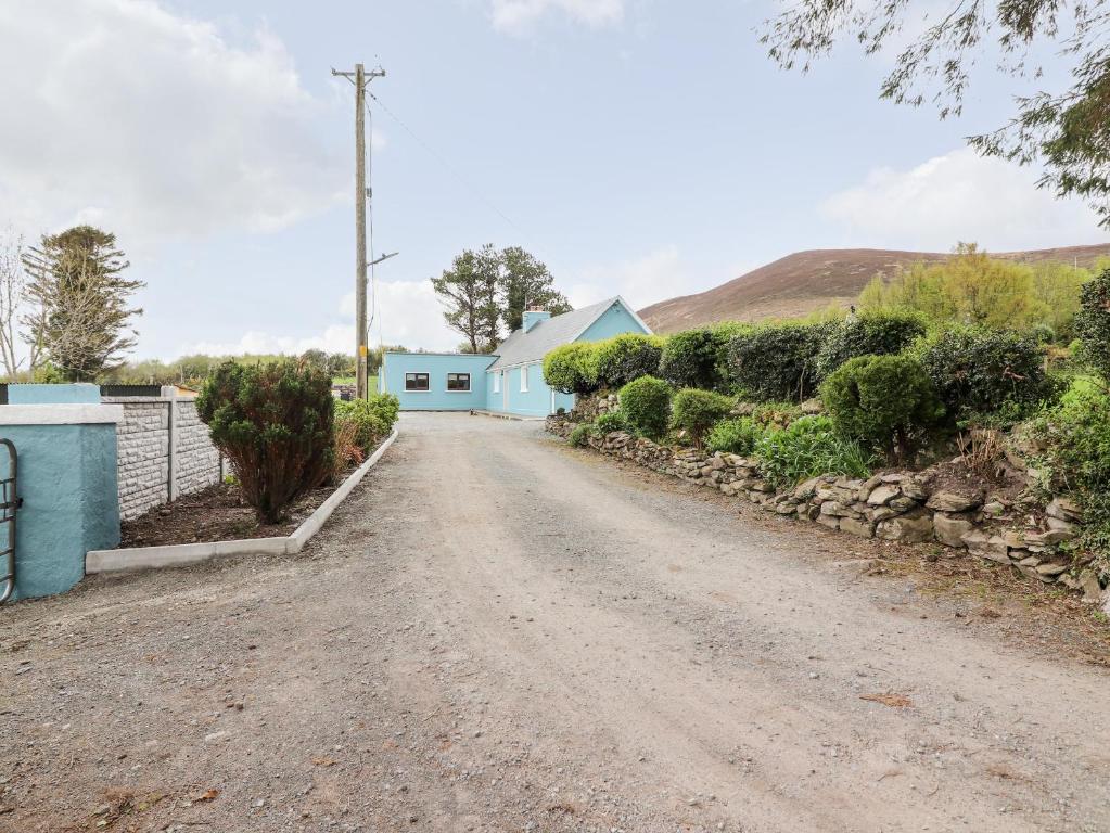 a dirt road in front of a blue building at Sweeney's Cottage in Beaufort