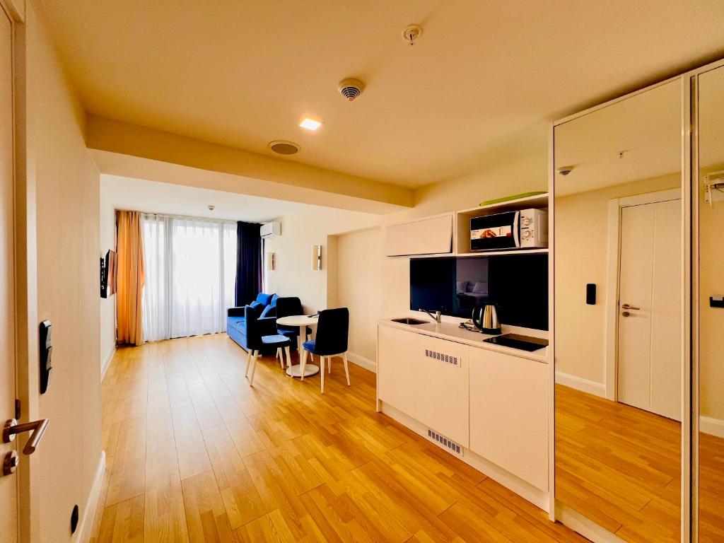 巴統的住宿－Luxsor Rooms In Orbi City，厨房以及带桌椅的起居室。