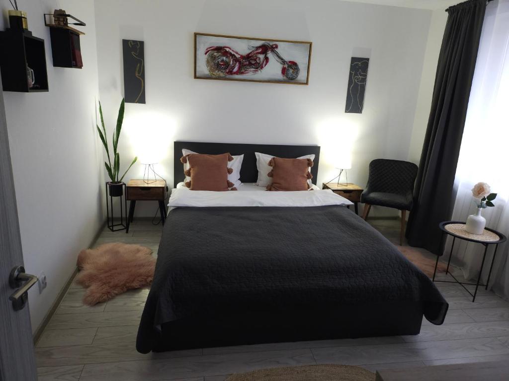 a bedroom with a large black bed with pillows at Nico in Piatra Neamţ