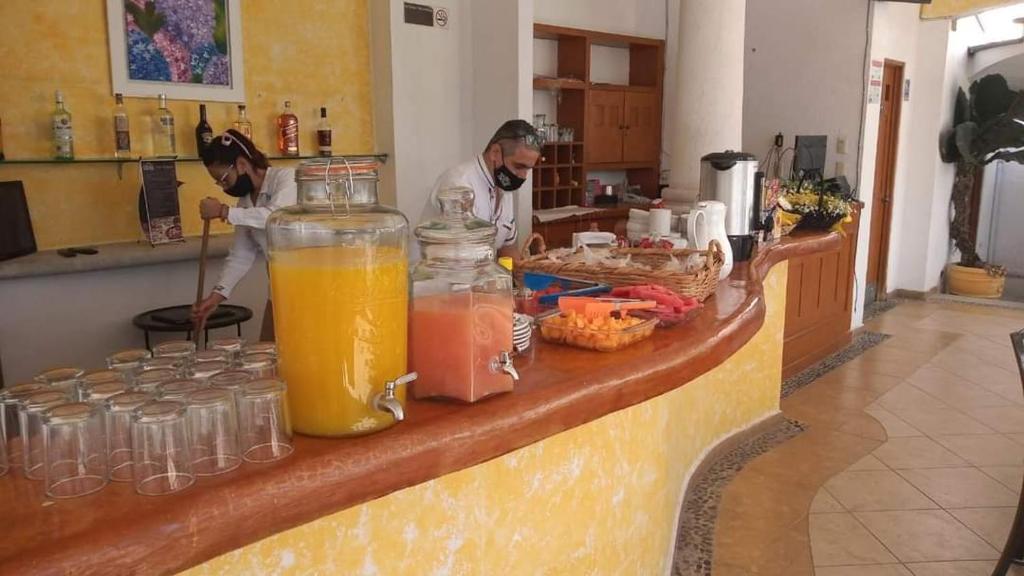 deux hommes dans une cuisine avec un comptoir avec des boissons dans l'établissement era hc, à Cuernavaca