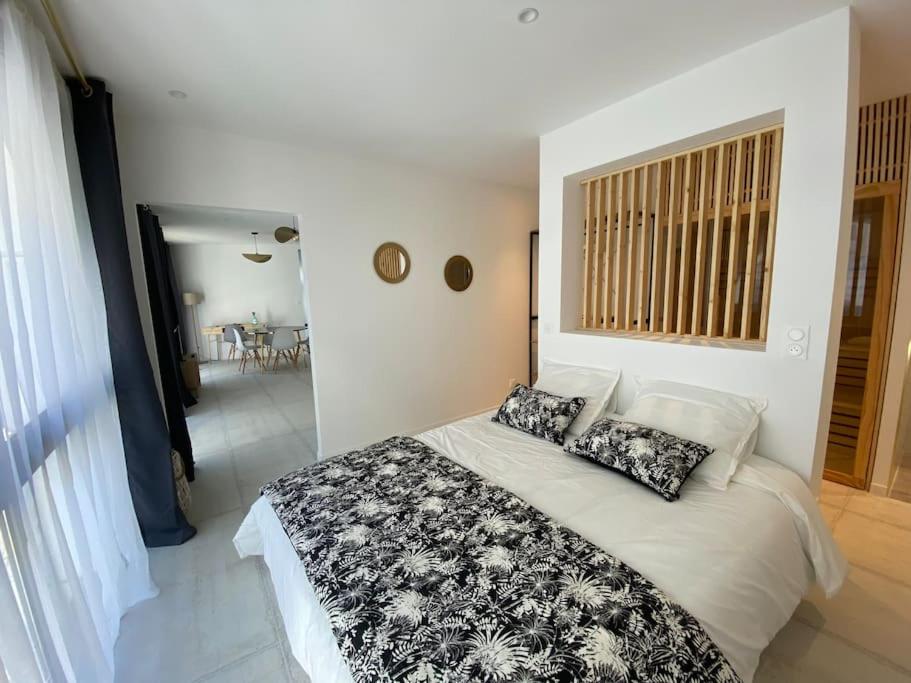 1 dormitorio con 1 cama con almohadas blancas y negras en Bordeaux cosy home, en Burdeos