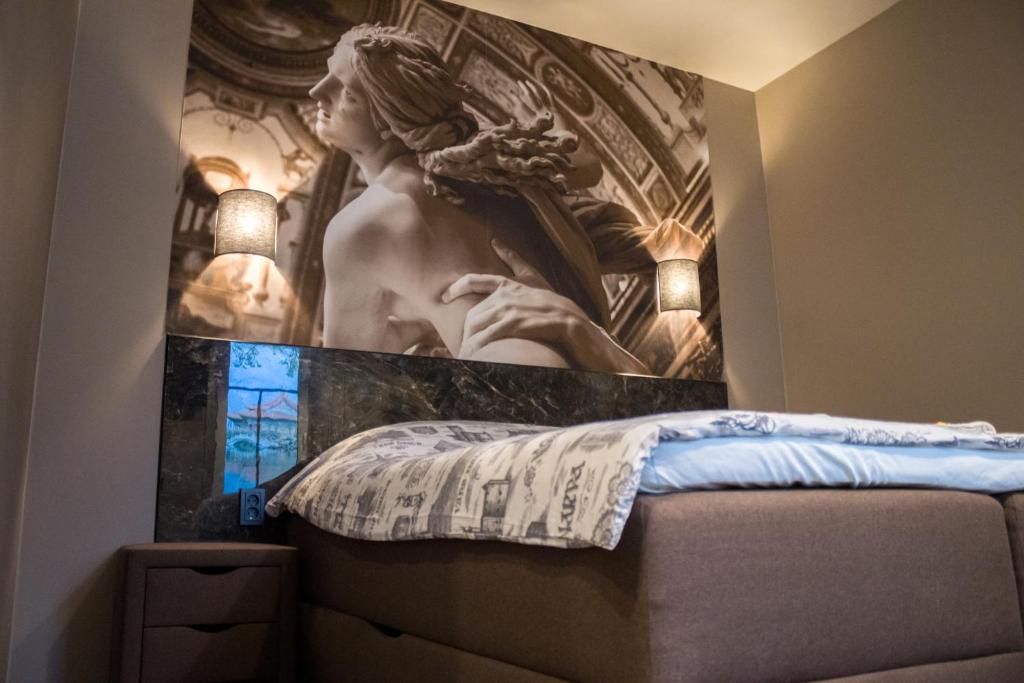a bedroom with a painting of a statue on the wall at Best apartments Narva in Narva