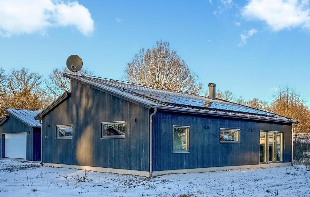 a blue house with snow on the ground at Awesome Home In Rockneby With Kitchen in Rockneby