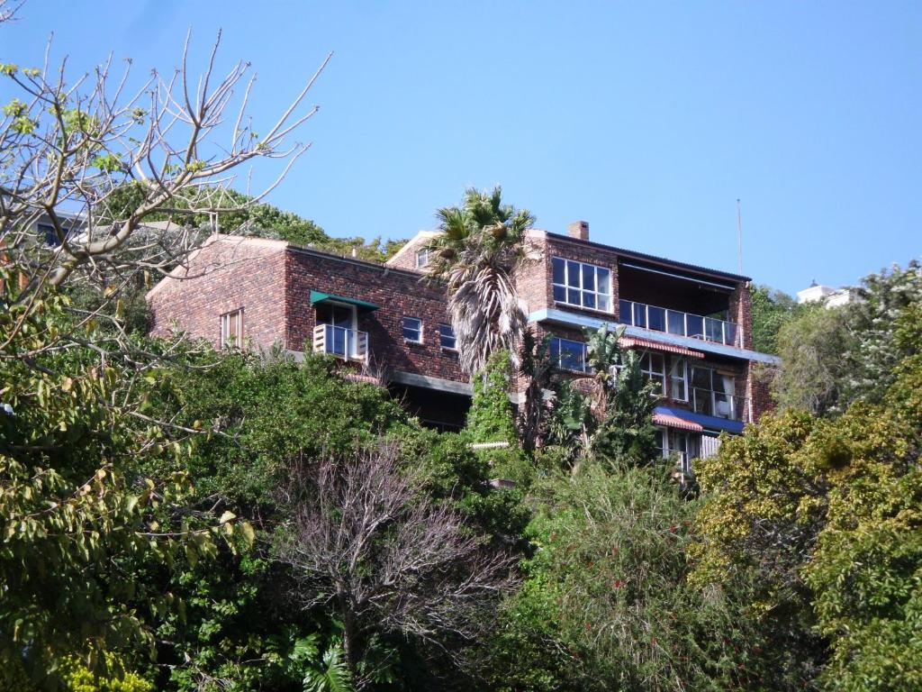 a house on the side of a hill with trees at Turaco in Knysna