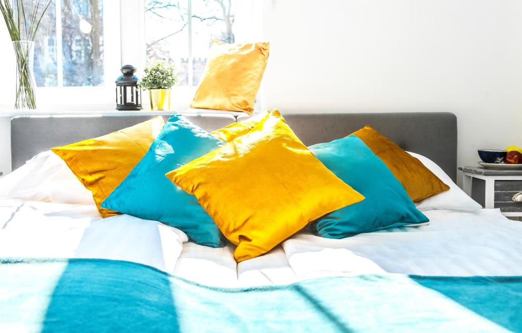 グダニスクにあるFamily Luxury Gold Apartament & Playstation, 1-6, 2 sypialnie i salon, 100m Bazylikaのベッド(黄色と青色の枕付)