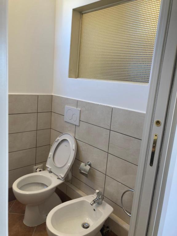 a bathroom with a toilet and a sink at Attico Verdi in Gorizia