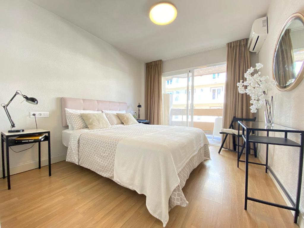 um quarto branco com uma cama e uma janela em Apartamento La Pimentera Marbella em Marbella