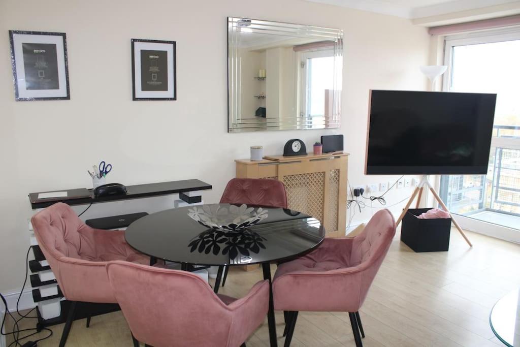 uma sala de estar com uma mesa e cadeiras e uma televisão em Urban Oasis: North London em Edmonton