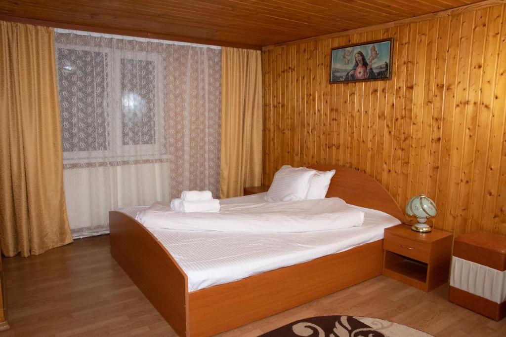 a bedroom with a bed and a window at Casa Luțea in Moieciu de Jos