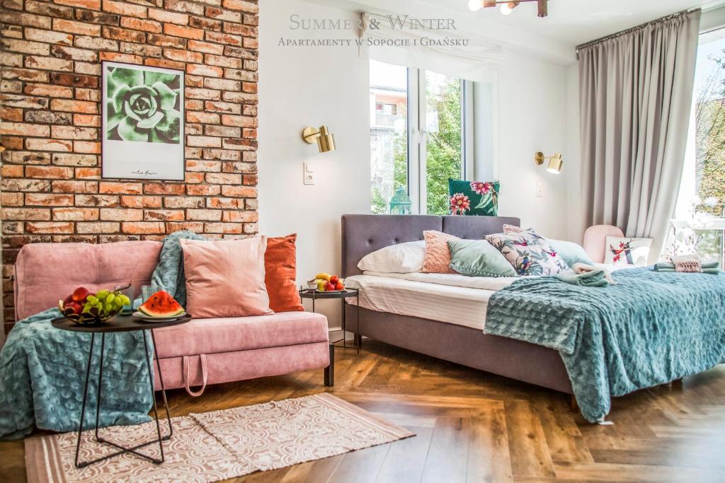 um quarto com uma cama e uma parede de tijolos em Family Luxury Pure Old Town Apartament & Playstation 4, 1-8, 2 sypialnie i salon, parking pub, 60m2 em Gdansk