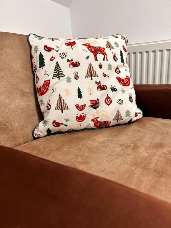 Un cuscino con motivi natalizi su un divano di Cabana Ruku a Muntele Băişorii
