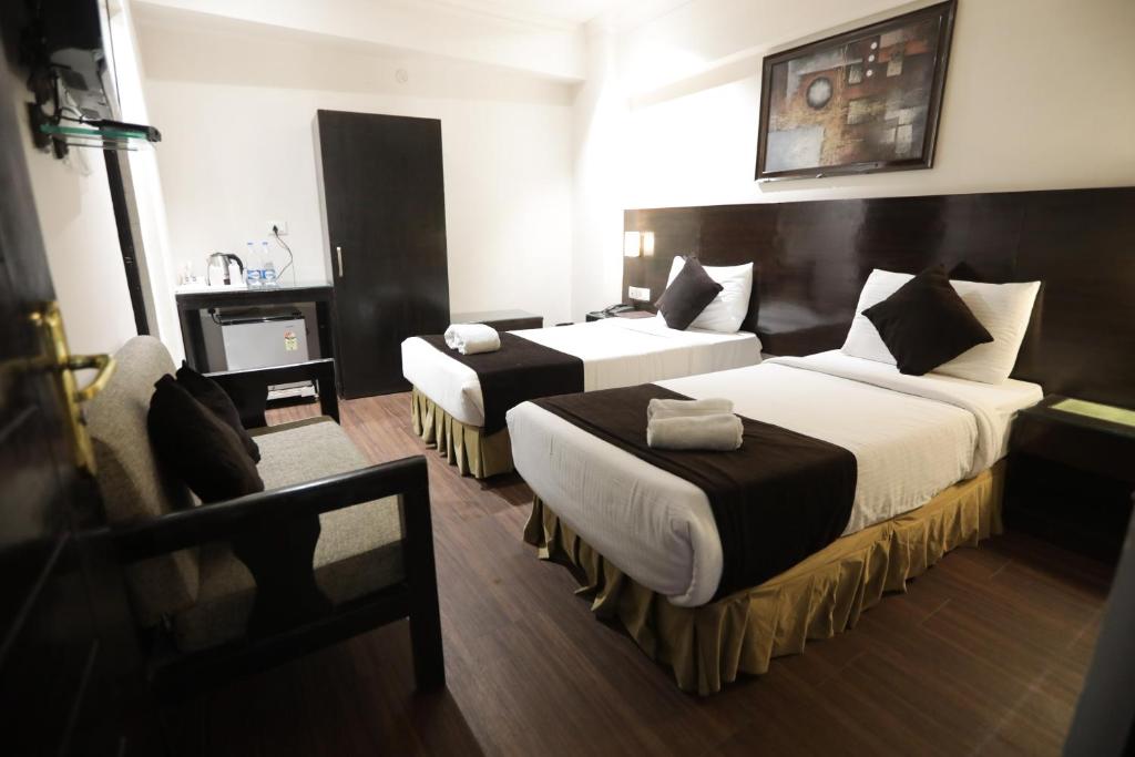 a hotel room with two beds and a fireplace at ANR Hotels in Lucknow