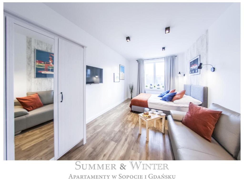 ein Wohnzimmer mit einem Bett und einer Couch in der Unterkunft Family Luxury Comfort Old Town Apartament, 1-8, 2 sypialnie i salon, parking w cenie, SUMMERWINTER Brand in Danzig