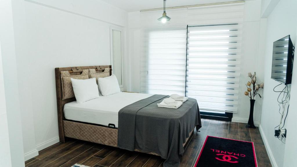 a bedroom with a bed with a table in front of a window at Port Marmaris Rooms in Marmaris