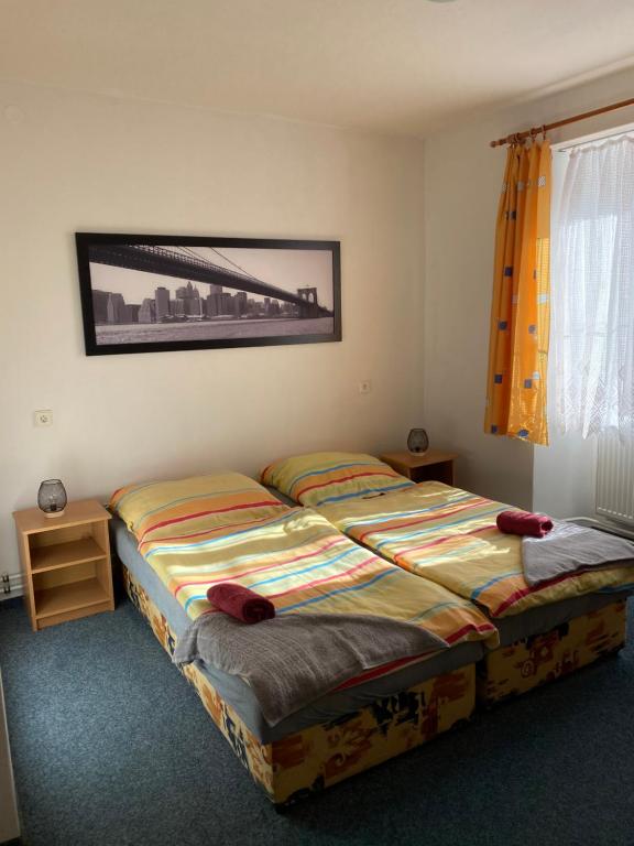 a bedroom with two beds and a picture on the wall at Penzion Tereza in Horní Vltavice