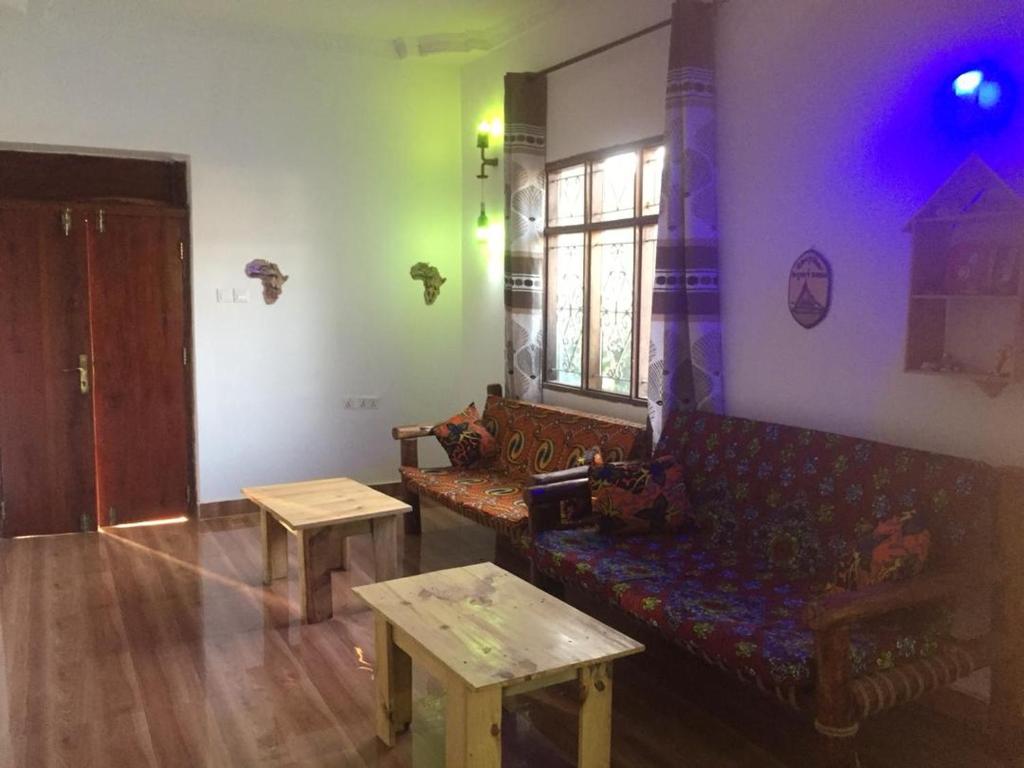 een woonkamer met een bank en een tafel bij Gabibo Kendwa Beach House in Kendwa