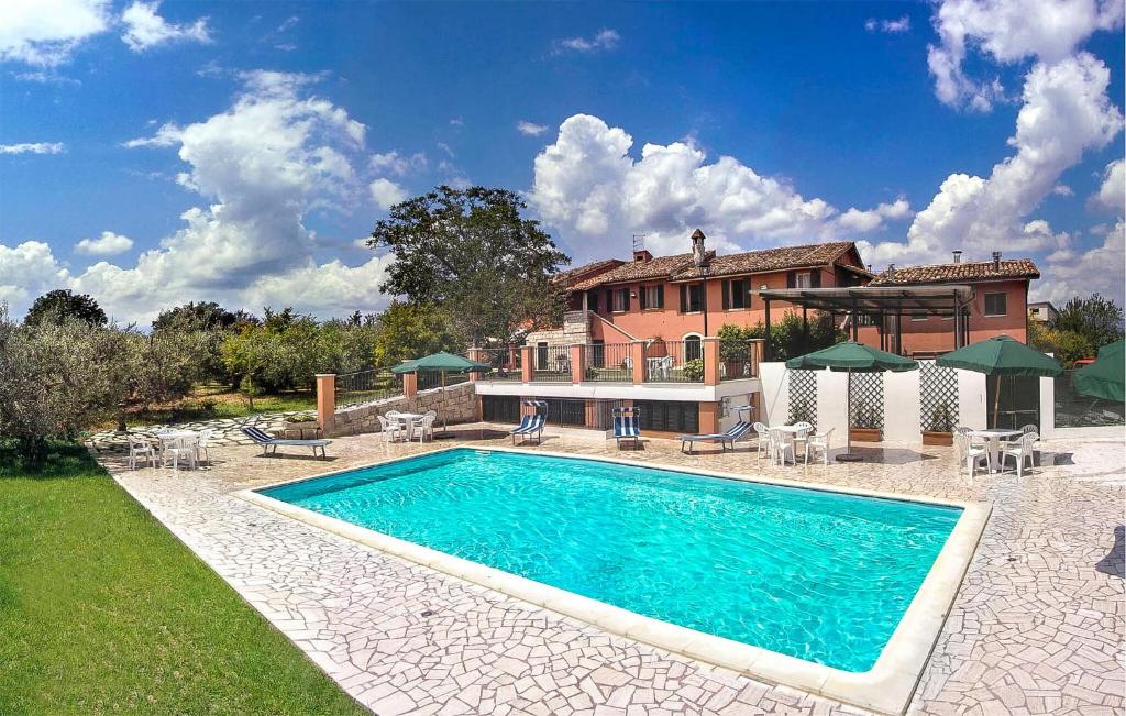 a large swimming pool in front of a house at Gorgeous Home In Ascoli Piceno With Wifi in Ascoli Piceno