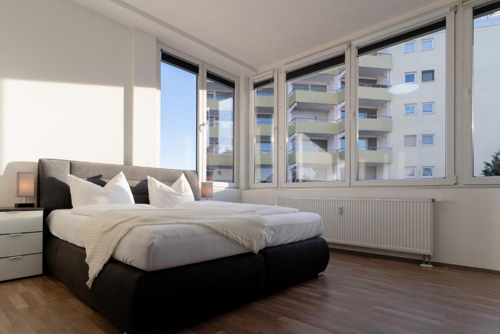 a bedroom with a large bed and large windows at Bodensee Loft - 116 m² Traumwohnung in Uhldingen-Mühlhofen