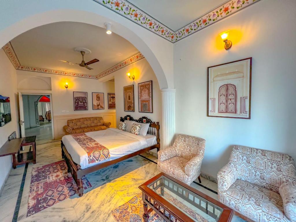 a bedroom with a bed and a couch and a chair at DYORE House in Jaipur