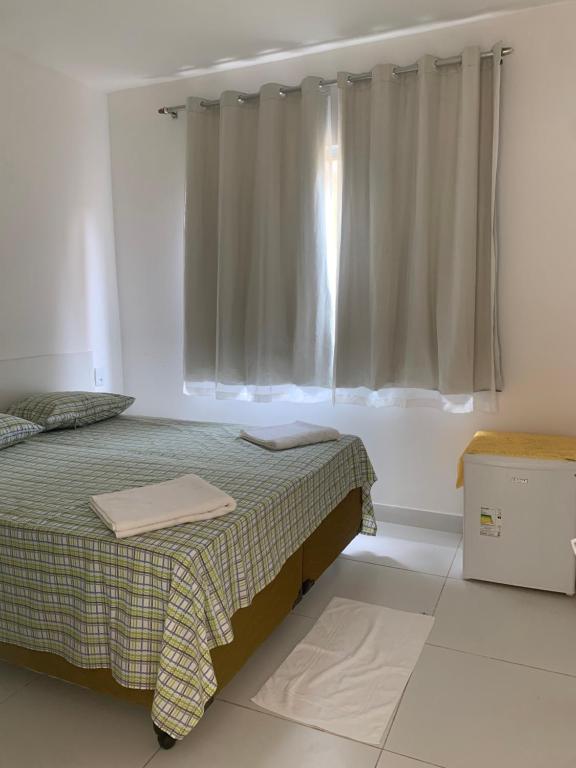 um quarto com uma cama e uma janela em VIRASSOL Praia Hotel em Salvador