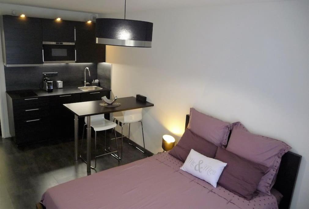 Cet appartement comprend une chambre avec un lit violet et une cuisine. dans l'établissement STUDIO Mr&Mrs, à Aix-en-Provence