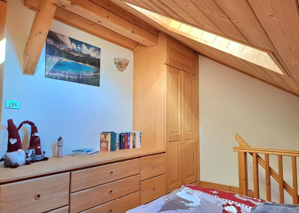 um quarto com uma cama e um tecto de madeira em Cèsa Pier Sellaronda Dolomiti em Campitello di Fassa