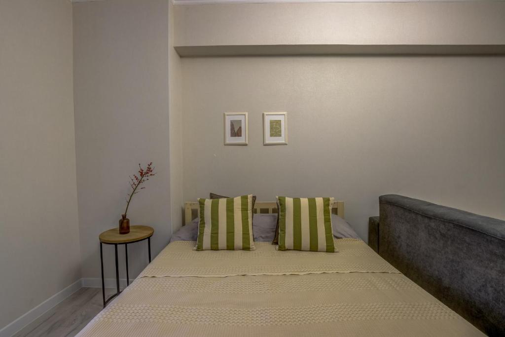 1 dormitorio con 1 cama con almohadas verdes y blancas en Quite apartment en Bishkek