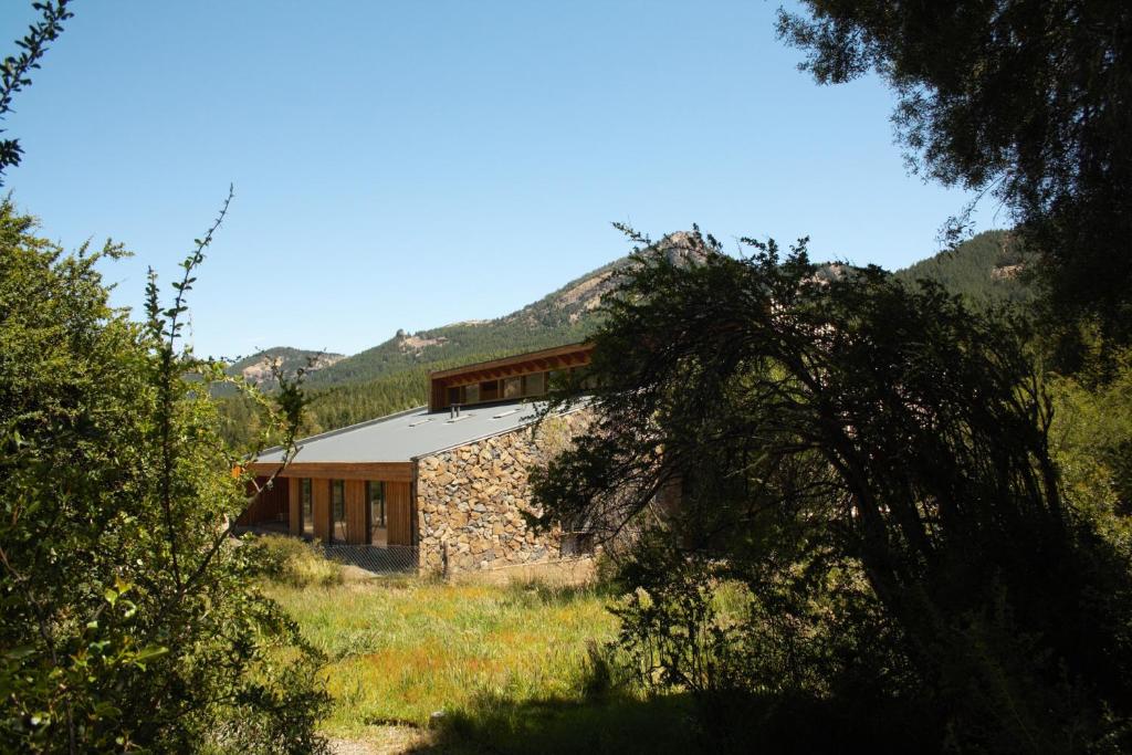 a stone house in the middle of a field at Calma Sur Hoteleria Boutique in Lago Meliquina