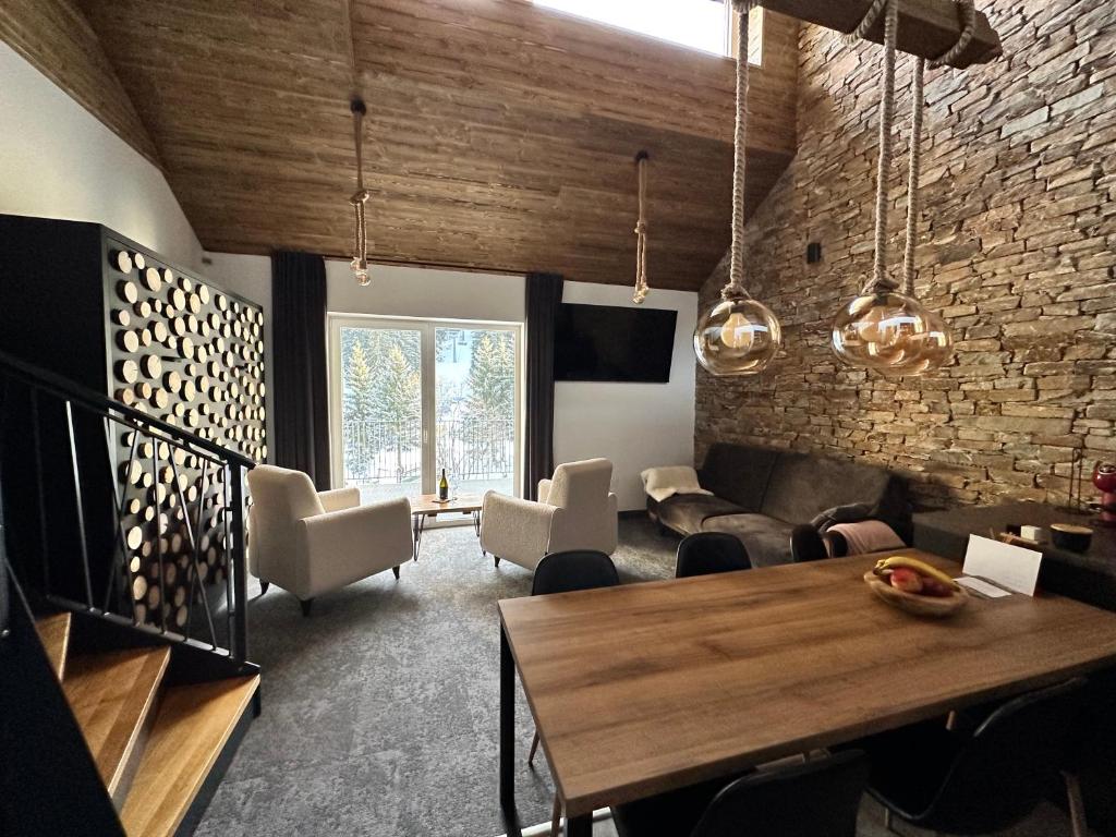 - un salon avec une table et des chaises en bois dans l'établissement Luxusní Apartmány Domovjanka - LYSÁ HORA A SMRK, à Bílá