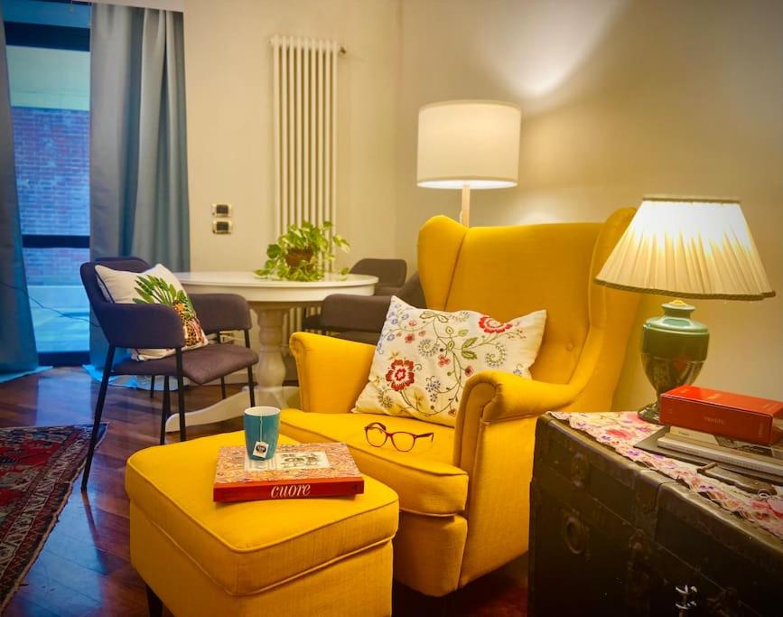 a living room with a yellow chair and a couch at Casa Melina - Venezia in Venice