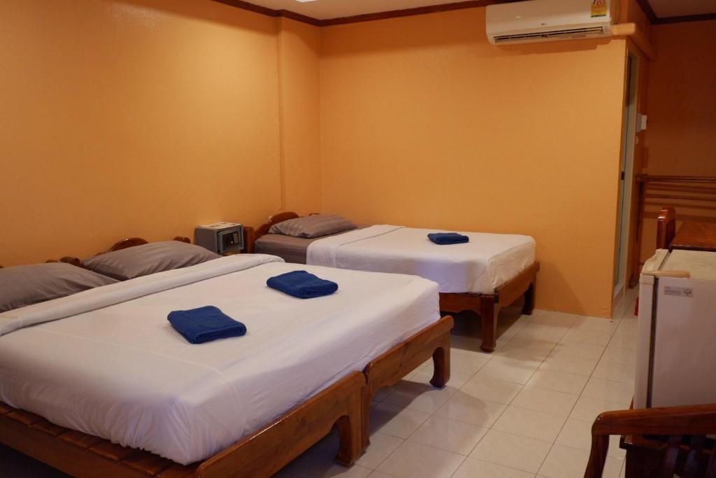 Habitación con 3 camas y toallas azules. en Goldbeach guesthouse, en Ko Chang