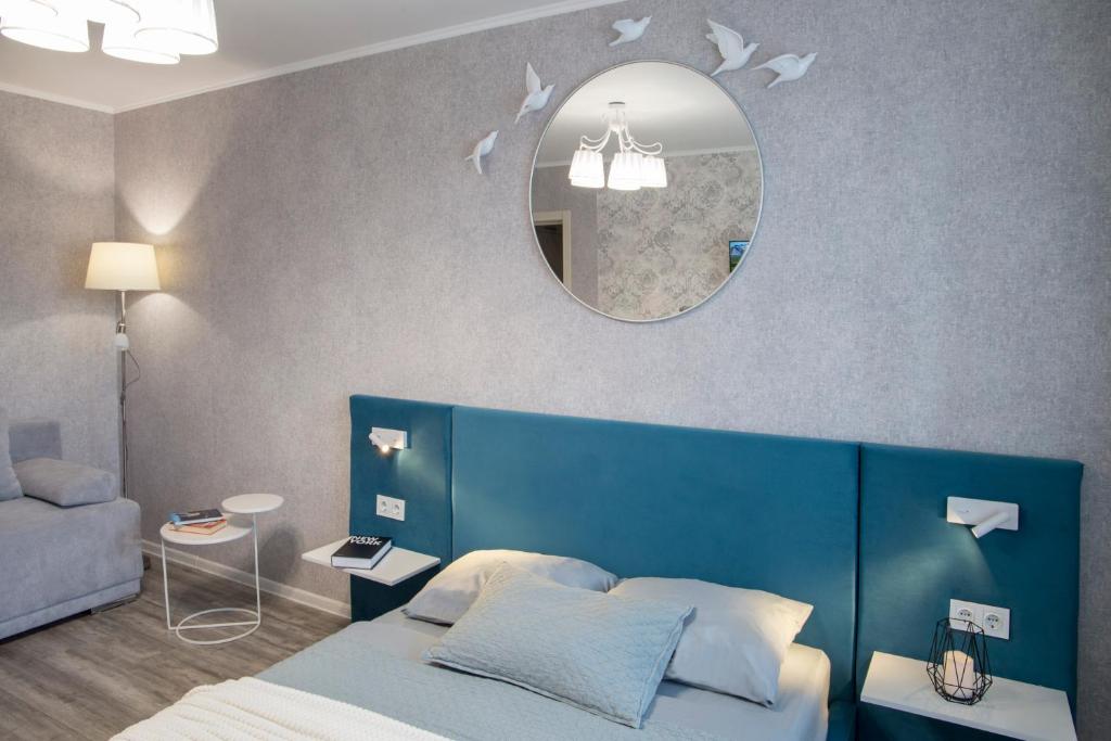 a bedroom with a blue bed and a mirror at Аппартаменты Металлист посуточно VIP in Kharkiv