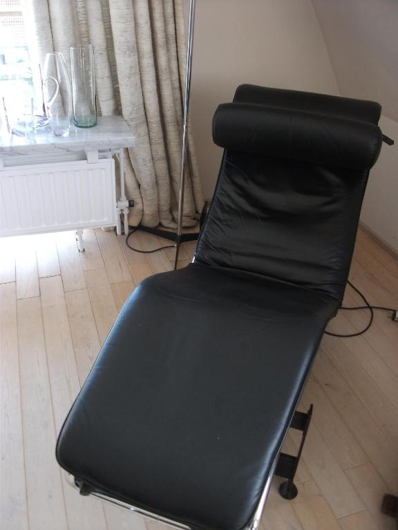 a black chair sitting in a room with a window at Zoutezoute in Knokke-Heist