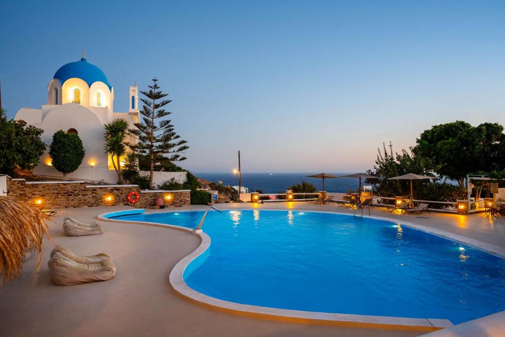 a pool in front of a church at night at Fanari Art in Ios Chora