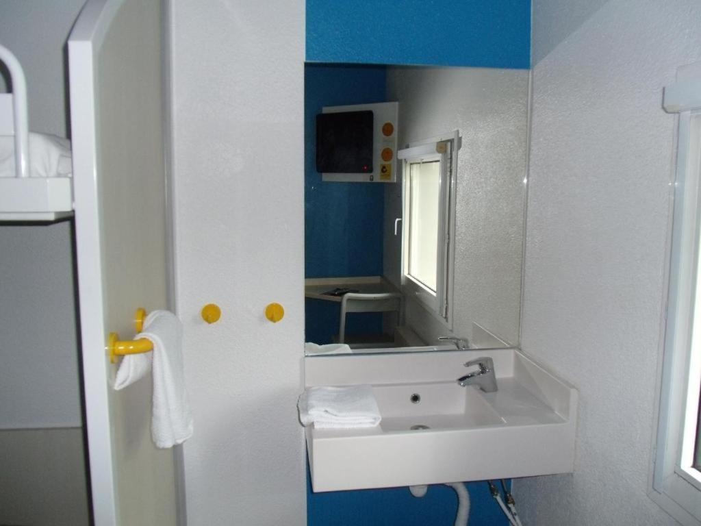 a bathroom with a white sink and a mirror at Multipropriété Easy Access Paris Porte de Versailles et La Défense in Issy-les-Moulineaux