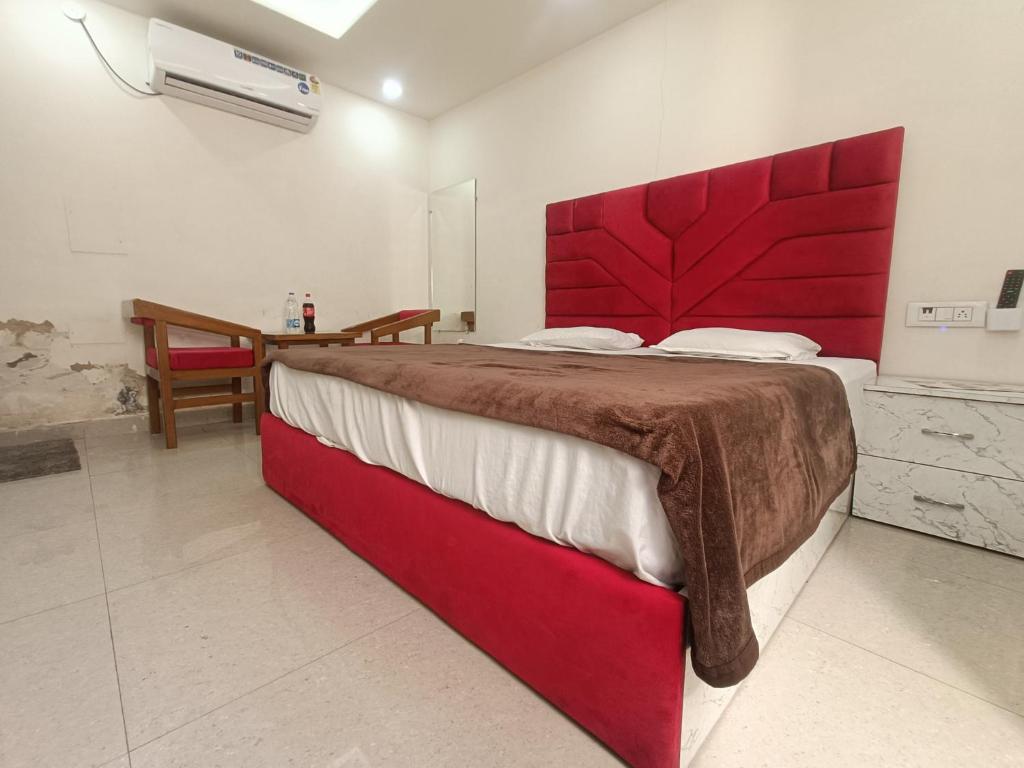 um quarto com uma cama grande e uma cabeceira vermelha em The Craft Hotel and Restaurant em Pānīpat