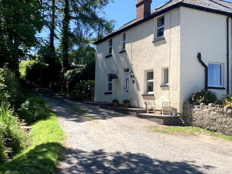 a large white house with a gravel driveway at Cosy Two Bedroom Cottage with Fireplace in Colwyn Bay