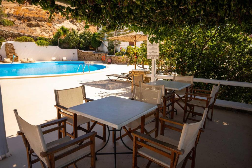 a table and chairs next to a swimming pool at Fanari Art in Ios Chora