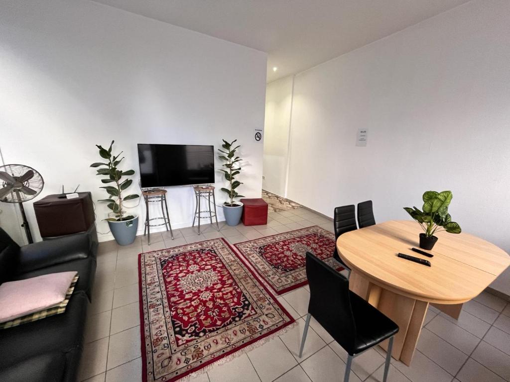 Hostel Wieden في فيينا: غرفة معيشة مع طاولة وتلفزيون