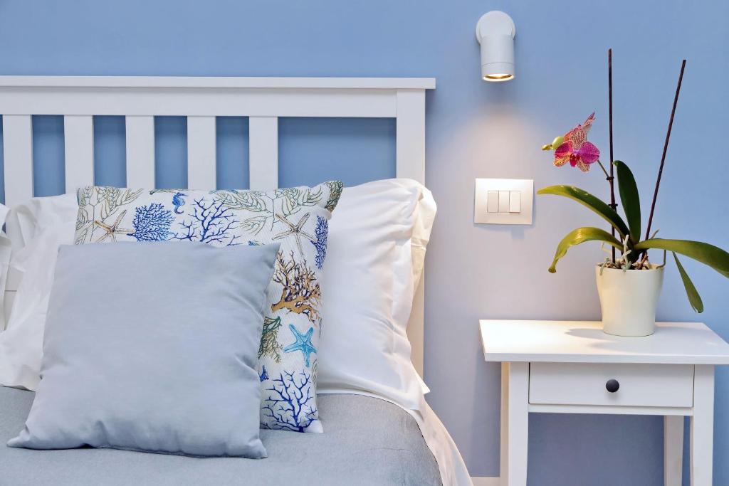 a blue bedroom with a bed with a pillow and a plant at PR APARTMENT - FIUMICINO ROME AIRPORT 9 Min - in Fiumicino