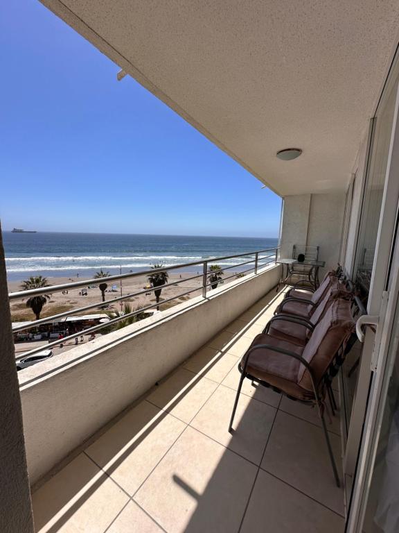 a balcony with chairs and a view of the beach at Mar Serena vista al Mar in La Serena
